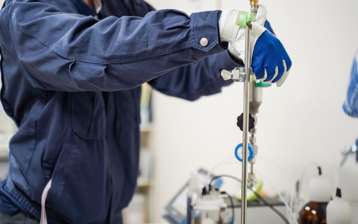 A person wearing gloves and holding equipment in a laboratory