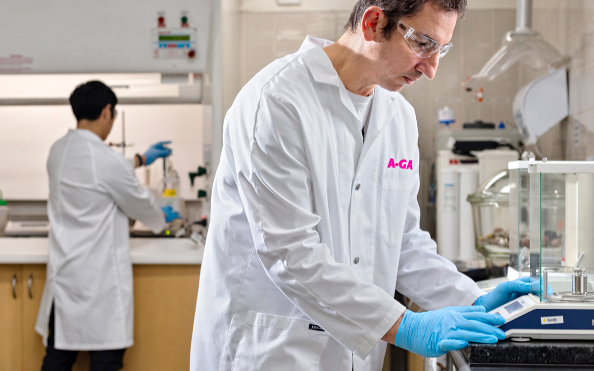 Two men in white coats working with equipment in a laboratory
