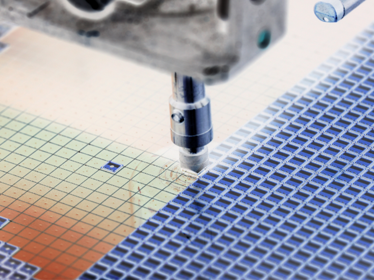 A mechanical needle filling in squares of blue etched ink