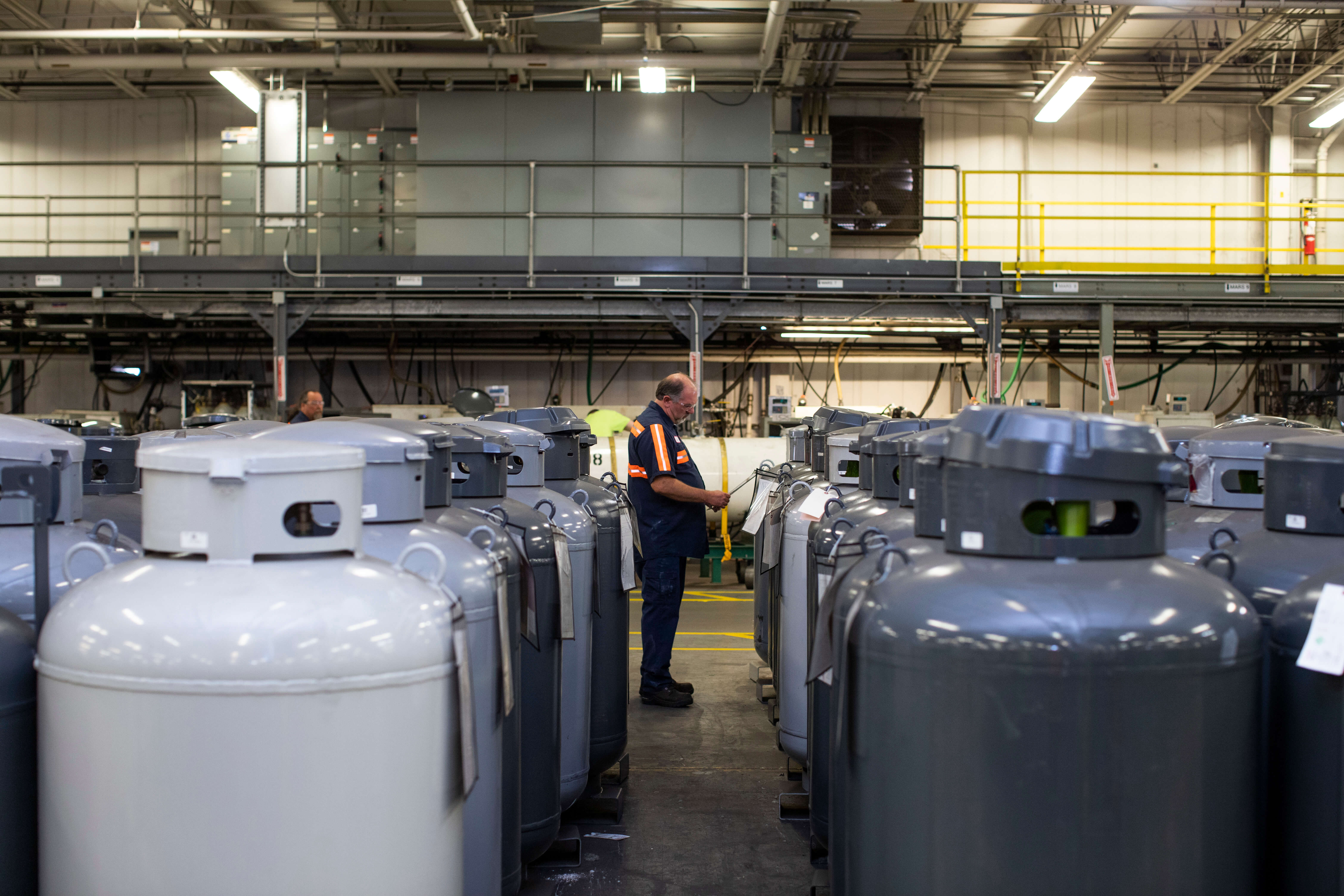 A person stood in the middle of rows of large grey iso cylinders