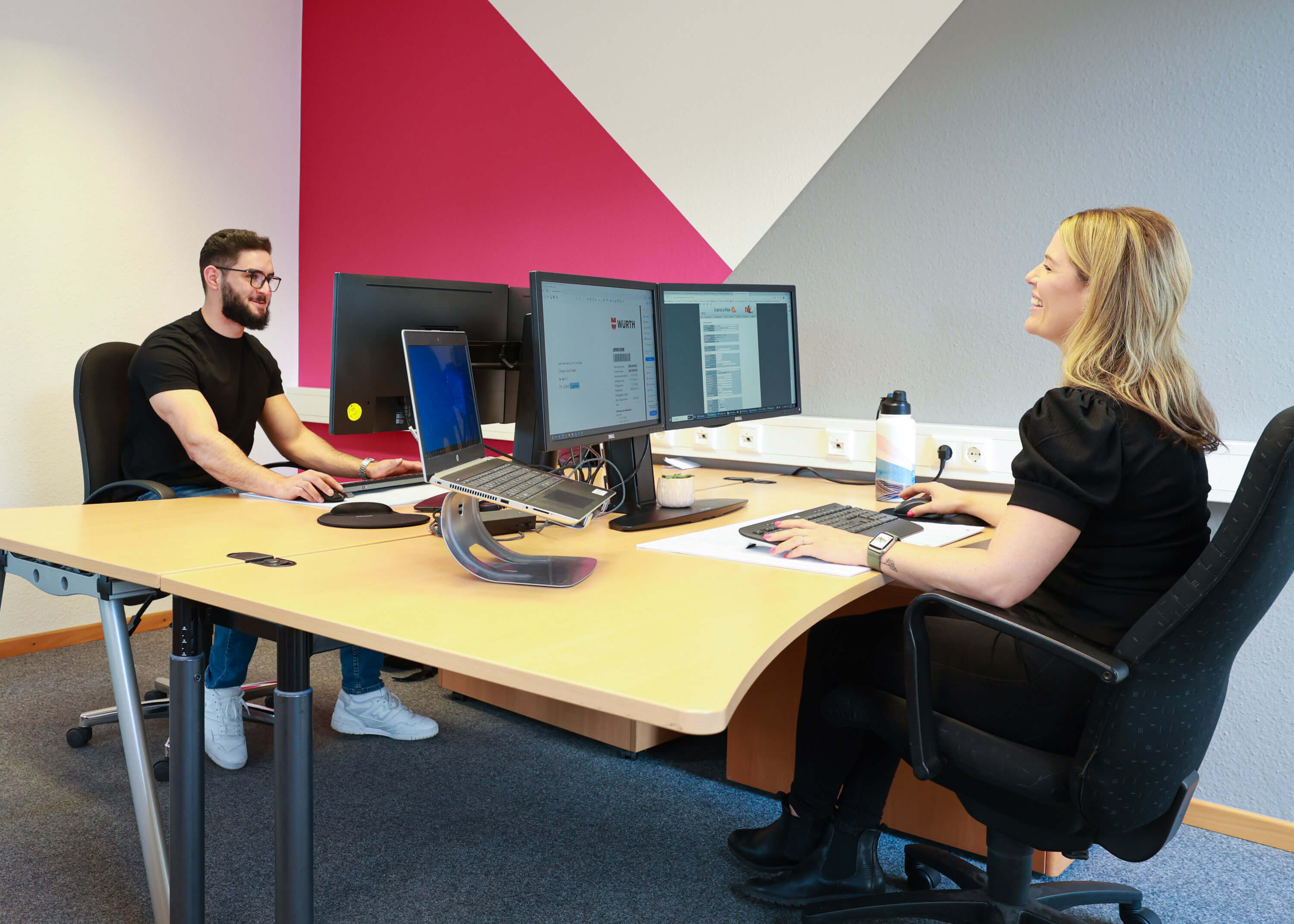 A man and a woman working at computers in an office 