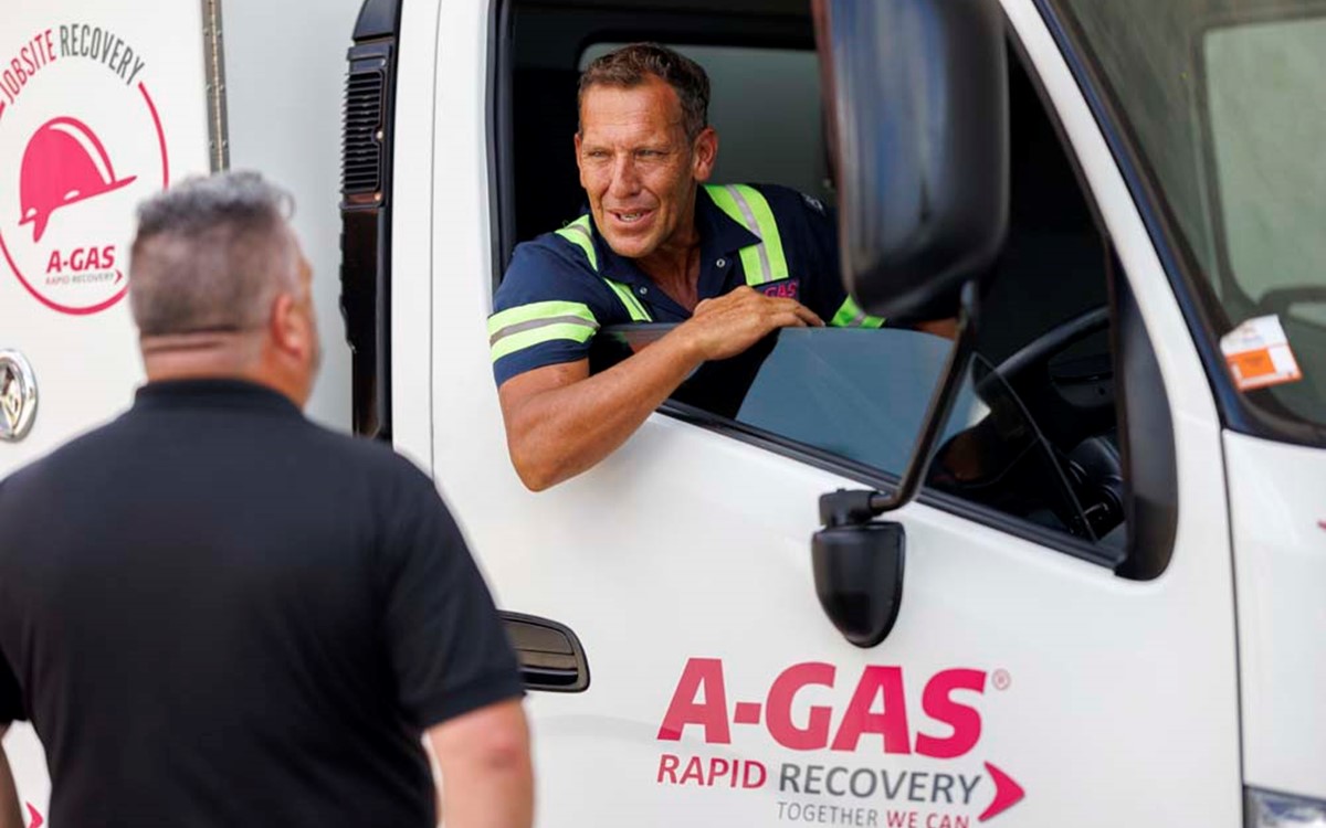 Two men talking through the window of a white van