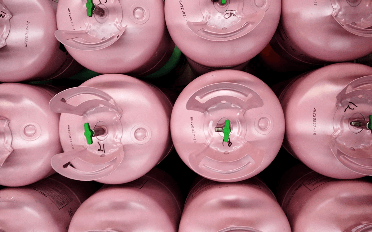 Rows of pink disposable cylinders with green valves from above