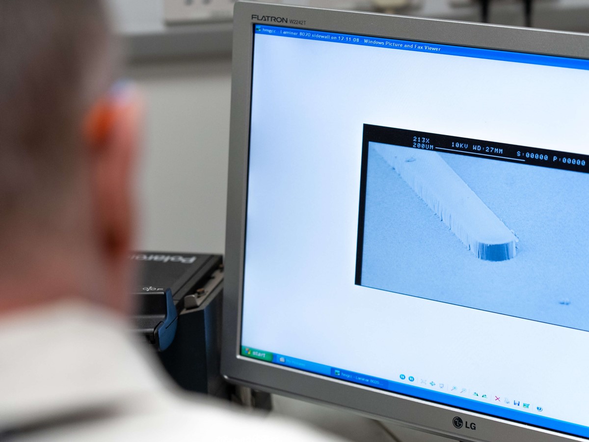 Man looks at computer screen from behind while working