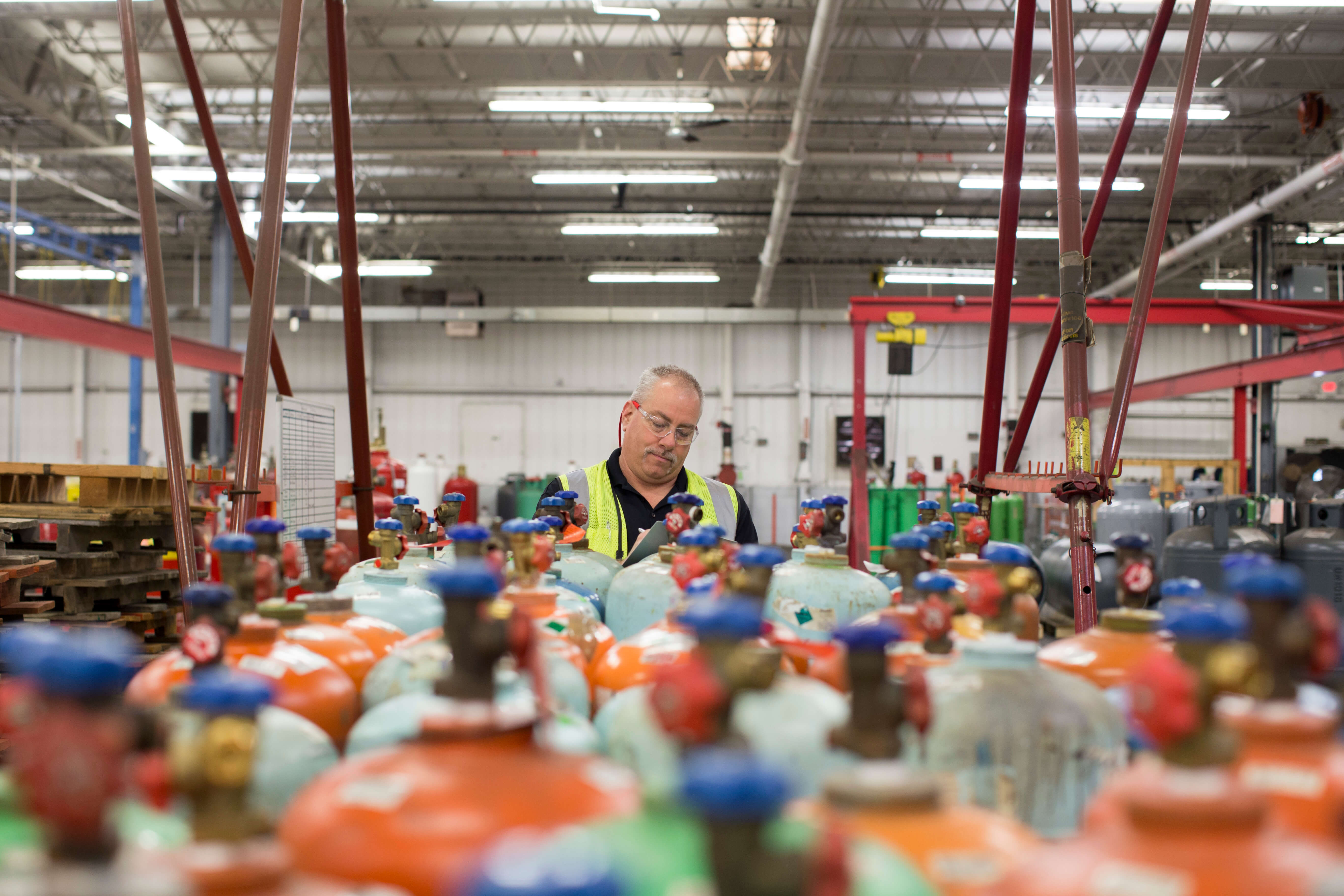 A warehouse worker stood behind rows of gas cylinders