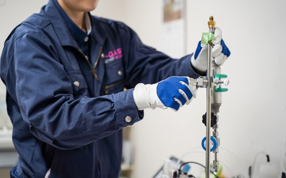 A man in a blue uniform works in a laboratory