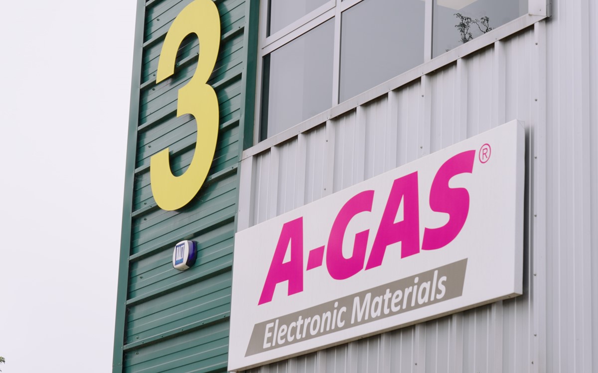 The outside of a grey and green building with pink A-Gas logo