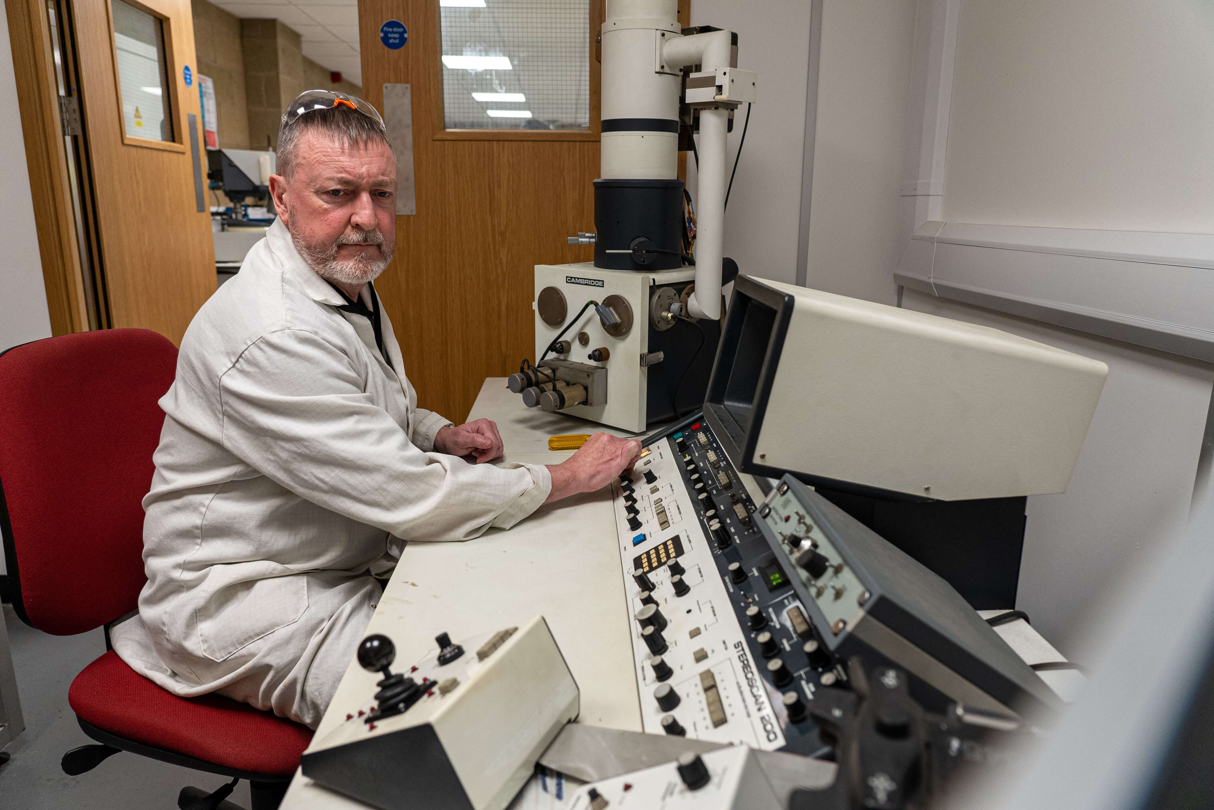 A man sitting at a desk while working with equipment 