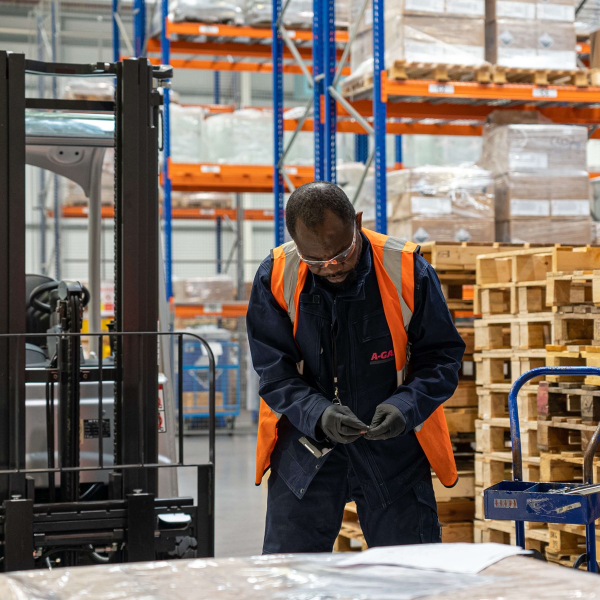 Man working with pallets of boxes in a warehouse