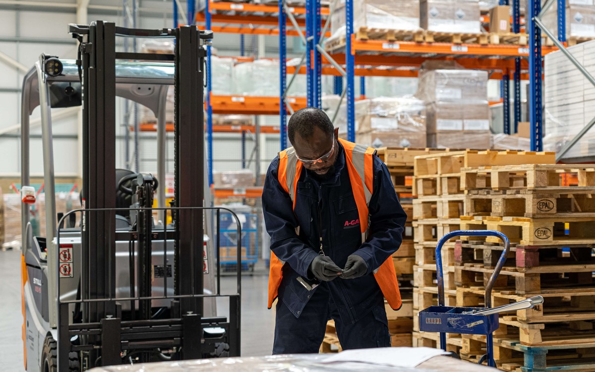 Man working with pallets of boxes in a warehouse