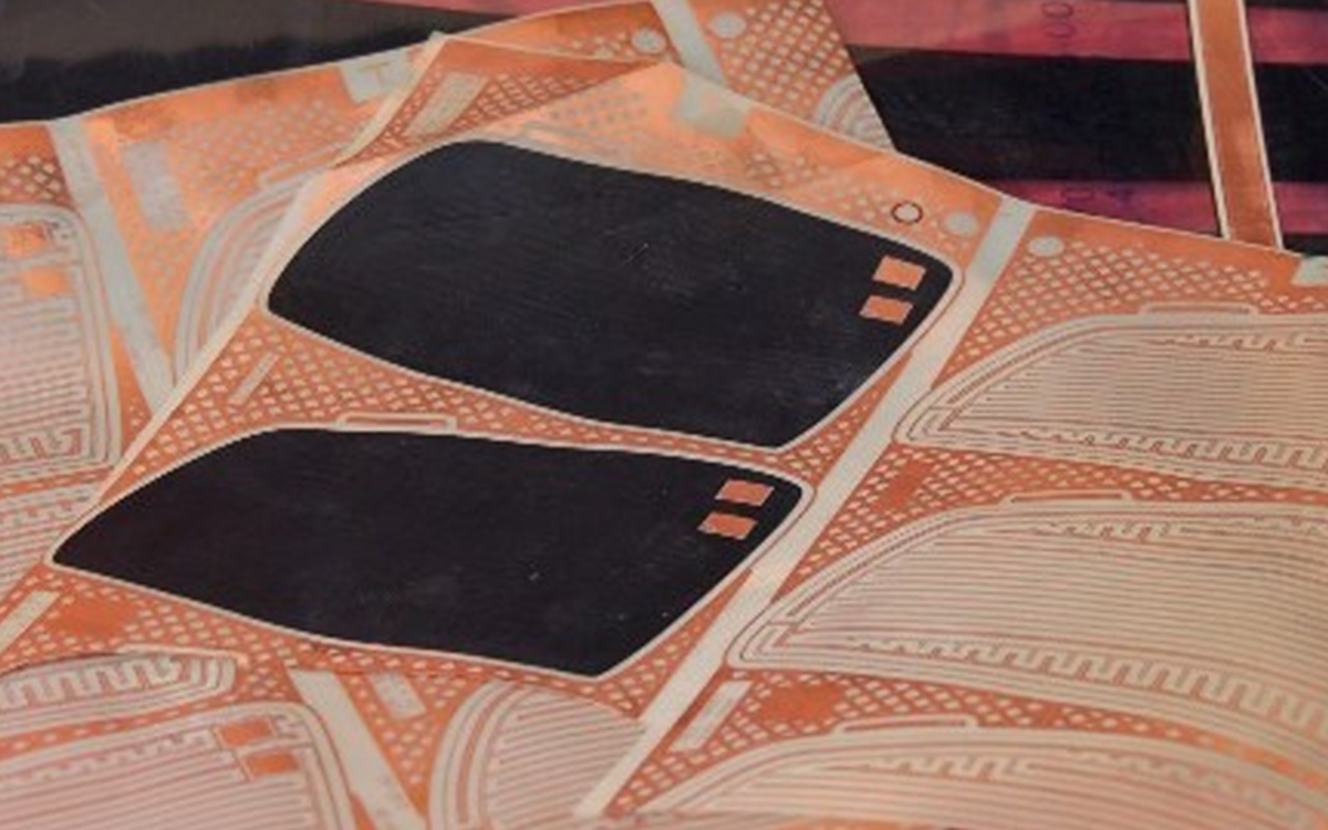 Two black shapes on orange printed material