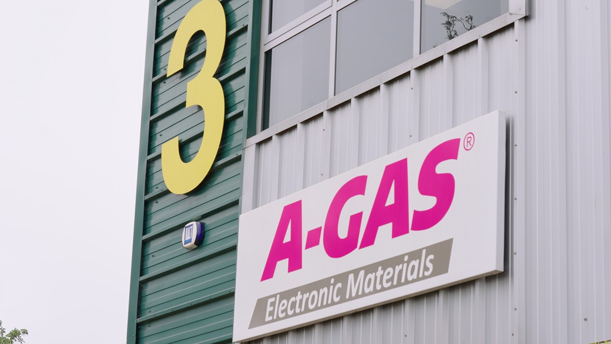 The outside of a grey and green building with pink A-Gas logo